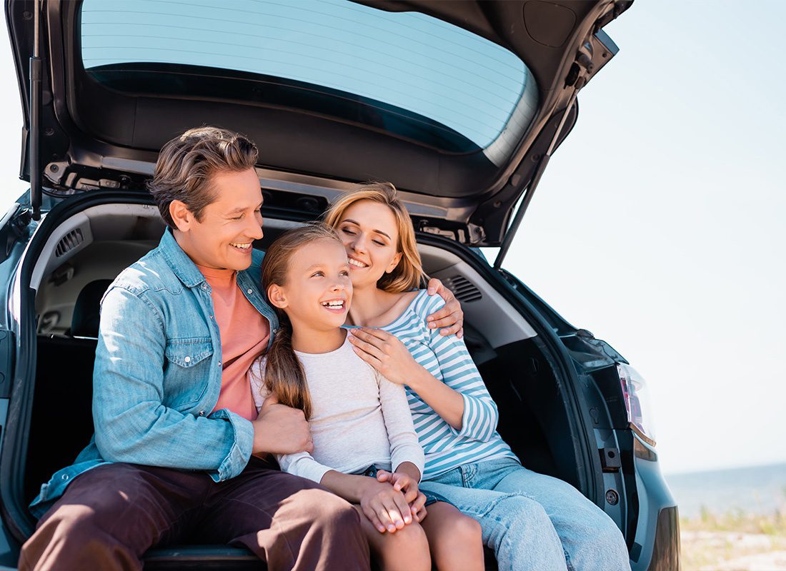 Personal Insurance - Man Hugging Wife and Kid While Sitting in Trunk of Car